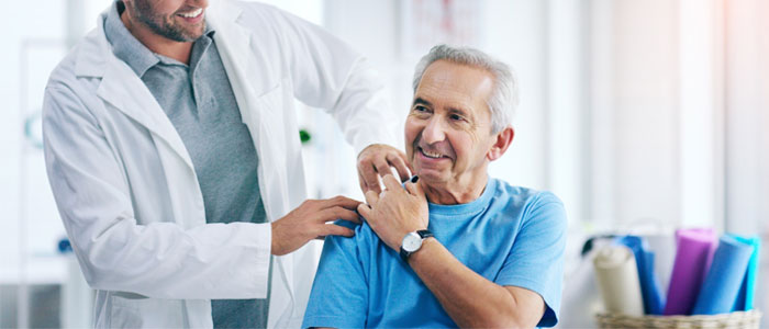 Doctor helping patient with shoulder